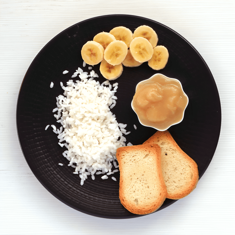 BRAT diet: rice, toast, and applesauce on a plate.