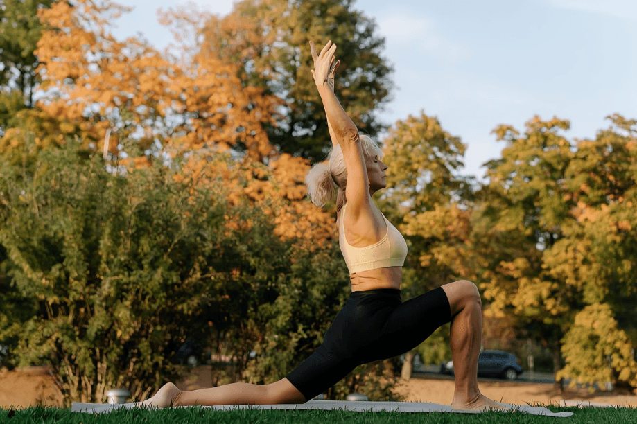 Woman doing a lunge yoga pose outdoors.