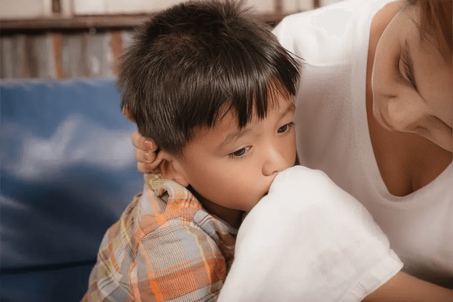 An adult comforts a child with a white towel.