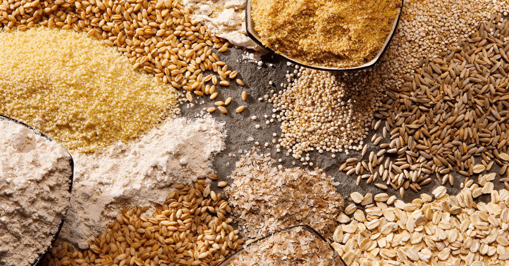 Various types of whole grains and flour, top-down.