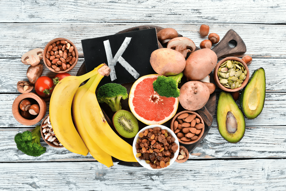 Various K-rich foods on a wooden background.
