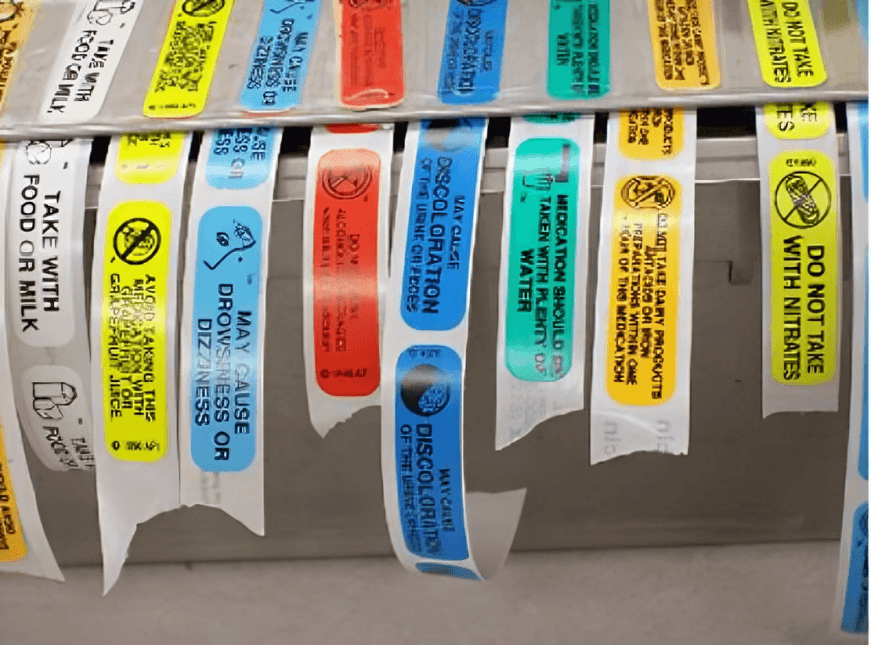Prescription warning labels on a metal dispenser.