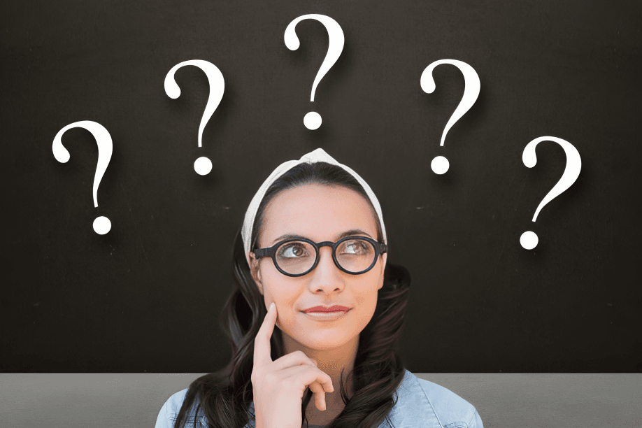 A young woman in glasses with question marks above.