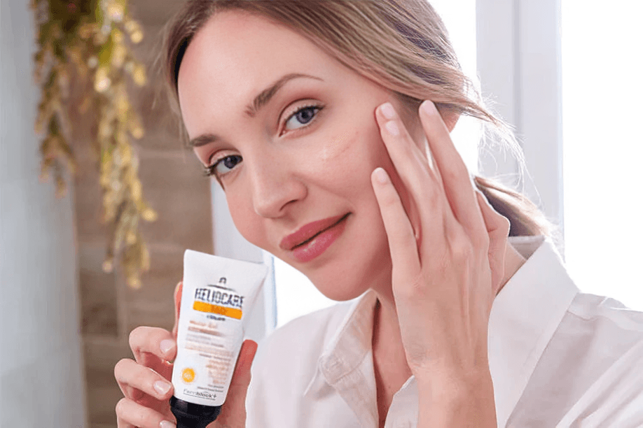A woman applying skincare product to her cheek.