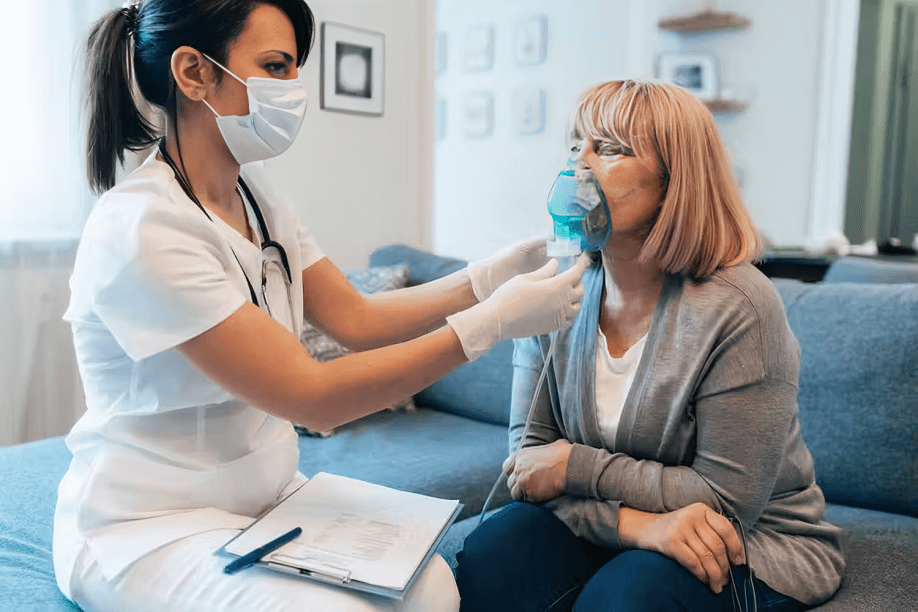 Nurse helping woman with oxygen mask.
