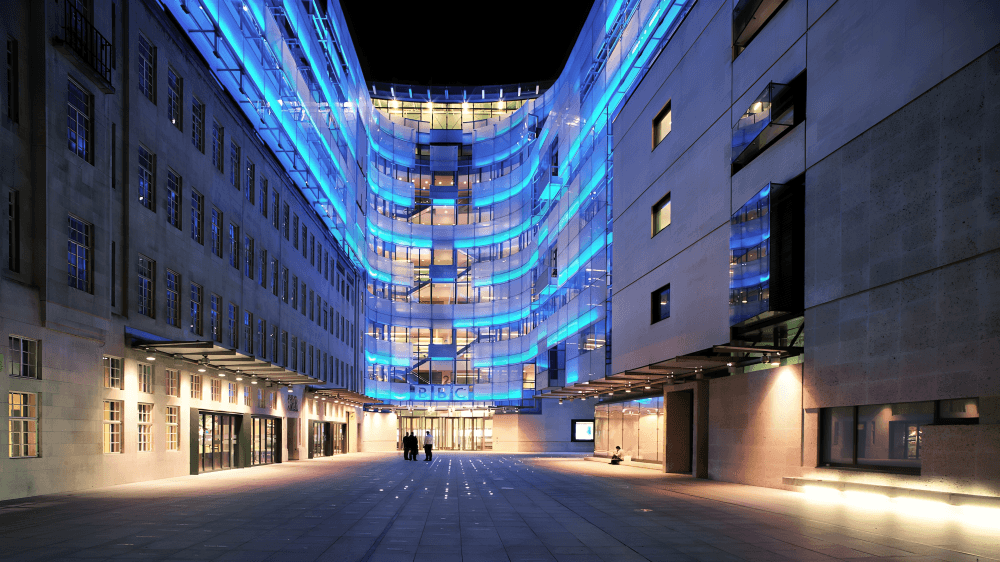 Night view of Broadcasting House with blue lights.