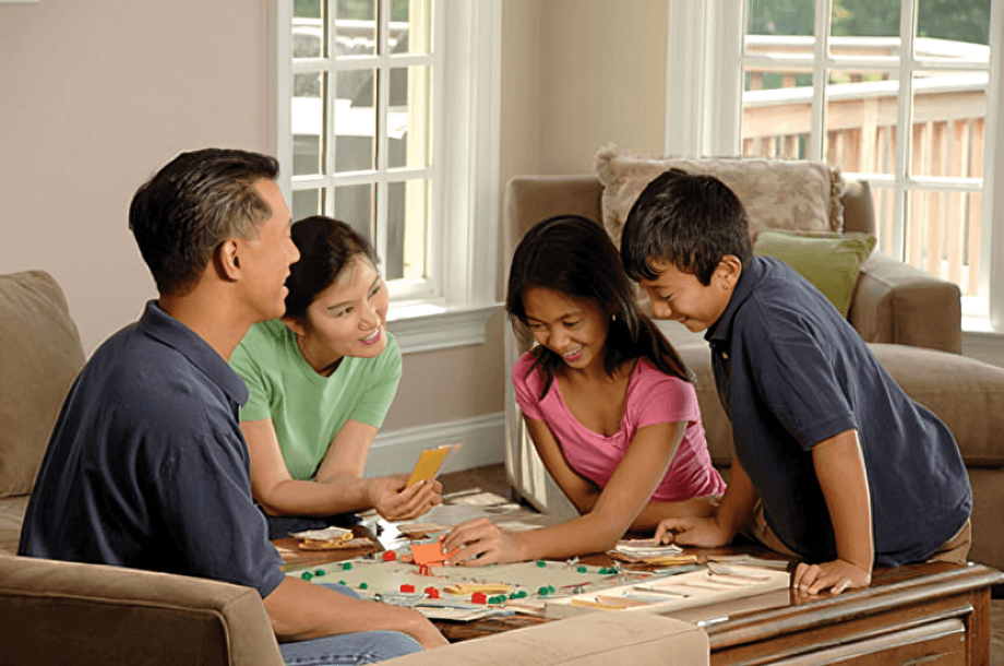Family of four playing a board game together.