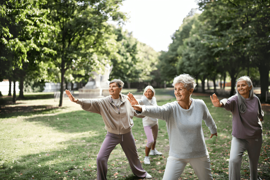 Group of senior women doing tai chi outdoors.