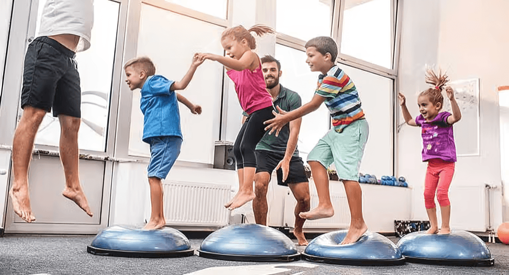 A group of childrens playing together with 2 mans.