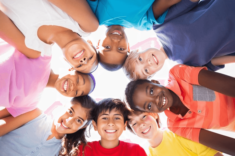 Smiling diverse children looking down into the camera.