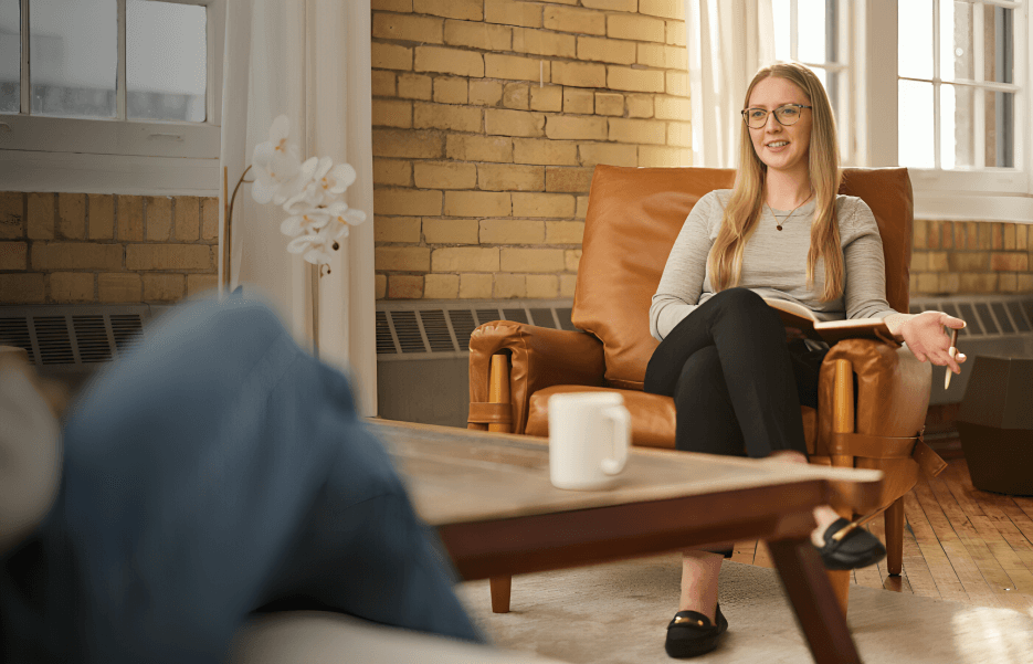 A therapist is talking to a patient in a cozy office.