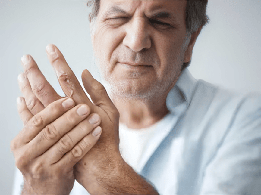 Elderly man holding hands due to pain.