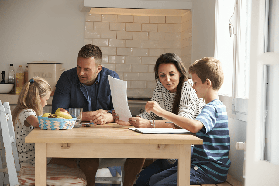Family (man, woman, boy, girl) at kitchen table.