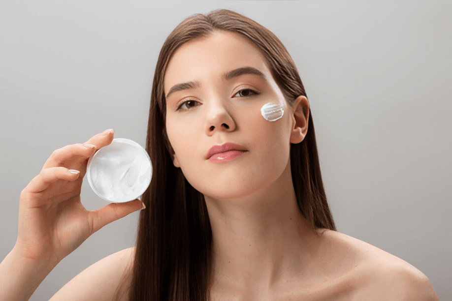 A woman holding a jar of face cream.