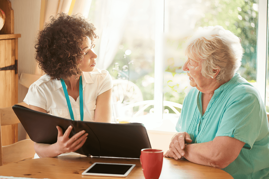 A home care worker talking with a senior woman.