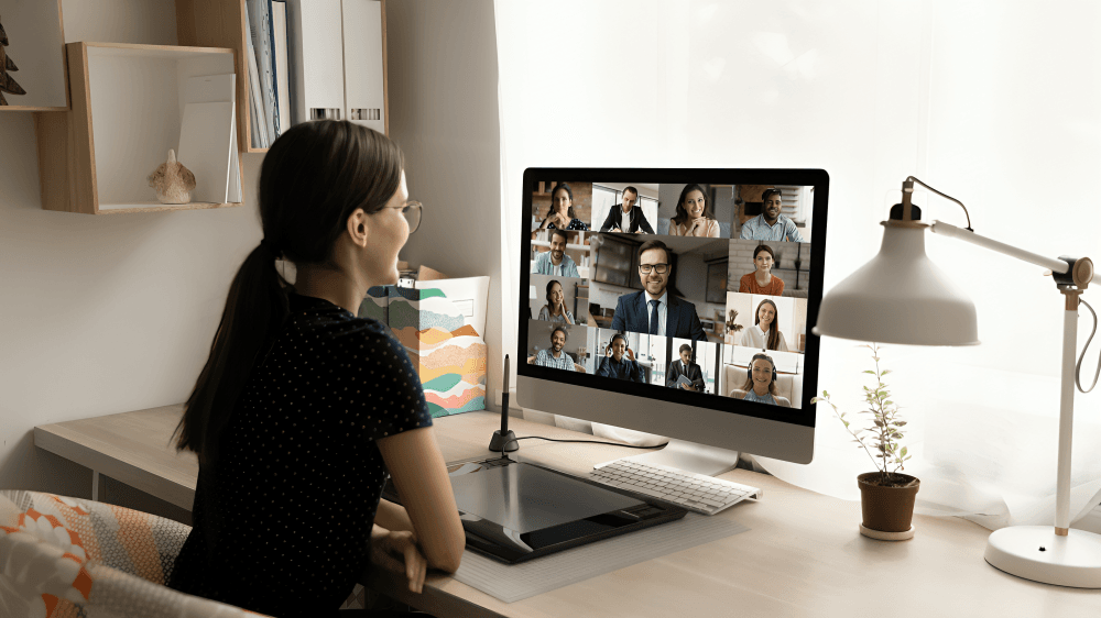 A woman participates in a video conference from her desk.