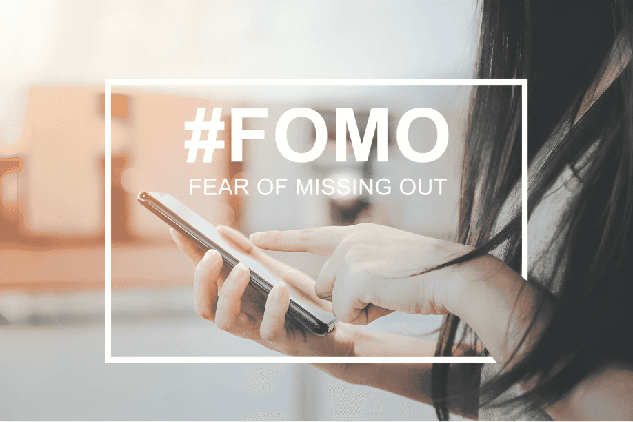 Person using phone, text overlay "#FOMO Fear of Missing Out".