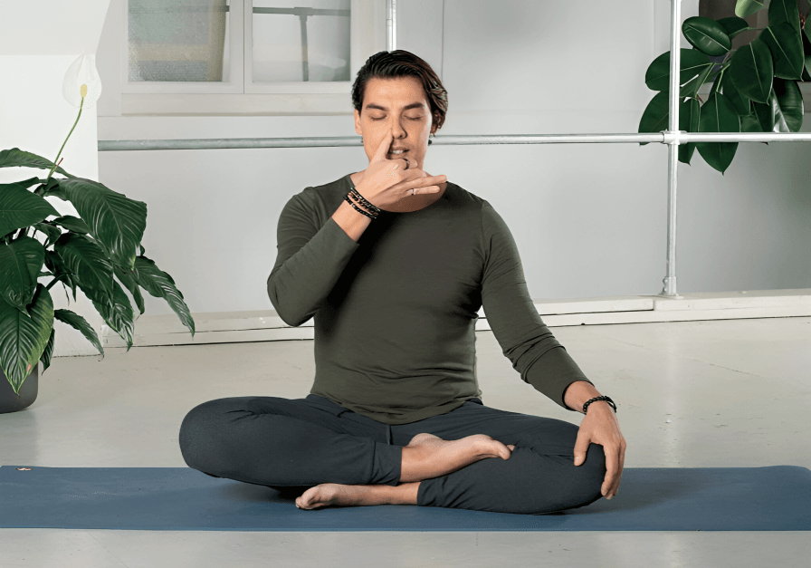 A man doing yoga, practicing alternate nostril breathing.