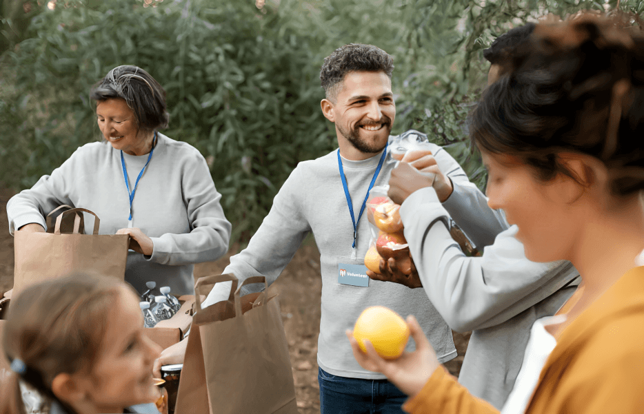 Volunteers distributing fresh produce at an outdoor event.