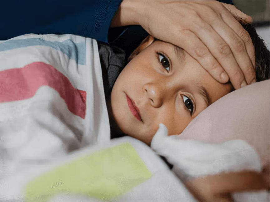 Close-up of an adult hand checking a child's forehead.