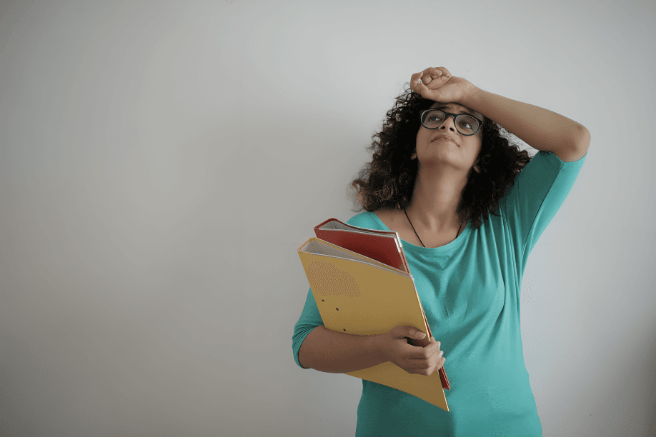 Woman with folders looking tired or overwhelmed.