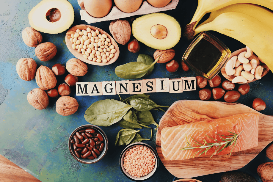 Magnesium-rich foods flat lay with nuts, fish, beans, and greens.