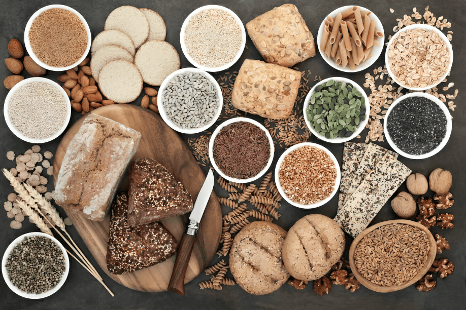 Overhead view of various whole-grain foods and bread.