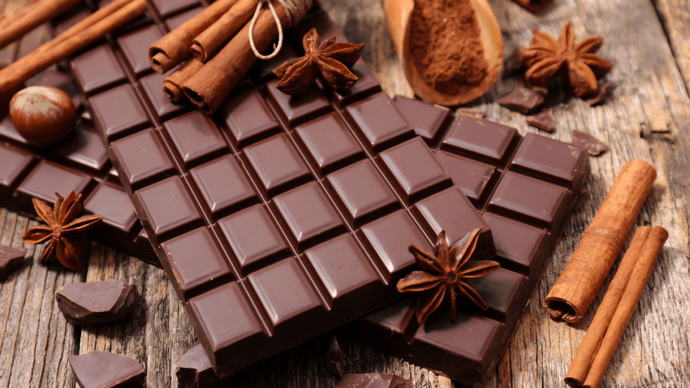 2 rectangular bars of dark chocolate on a wooden table