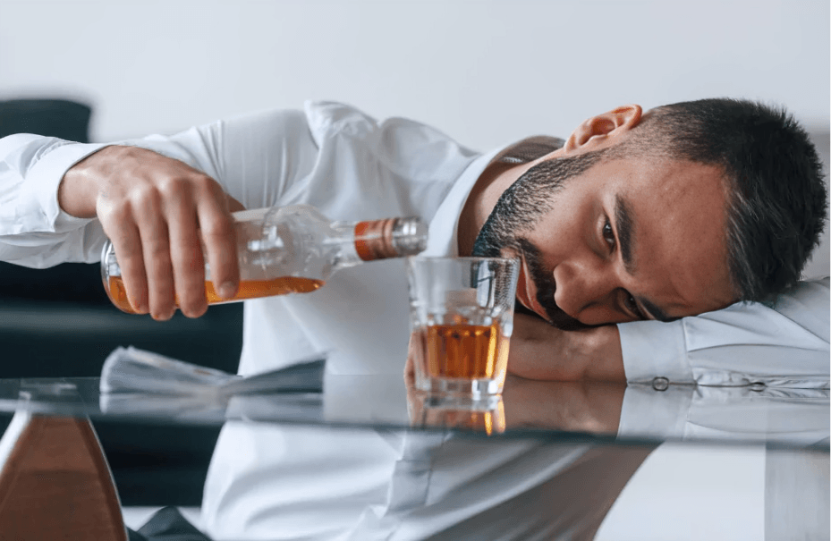 Man pouring alcohol, appearing drunk or unwell.