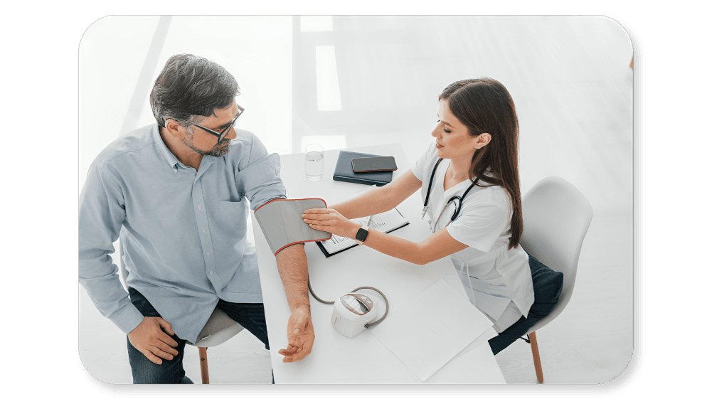 Doctor checking patient's blood pressure in bright office setting.
