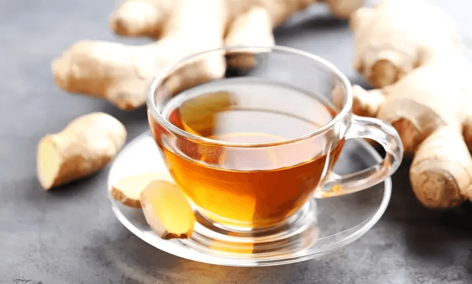 A cup of ginger tea with fresh ginger.
