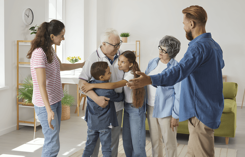 Three generations of a family embracing indoors.