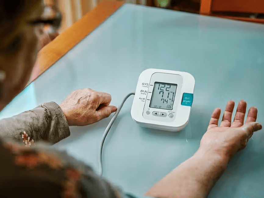 A person using a home blood pressure monitor.