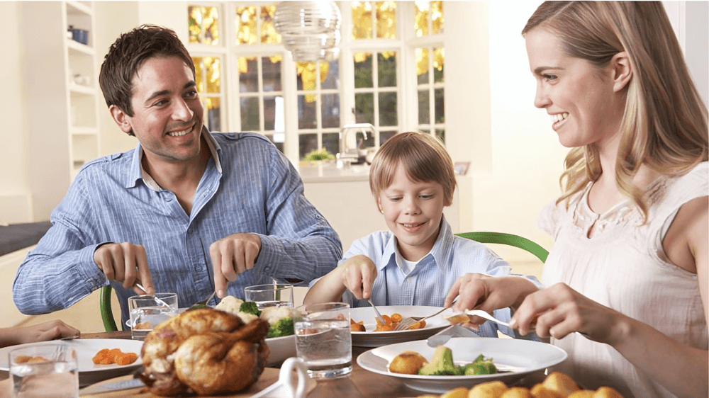 A family of three enjoying a meal together.