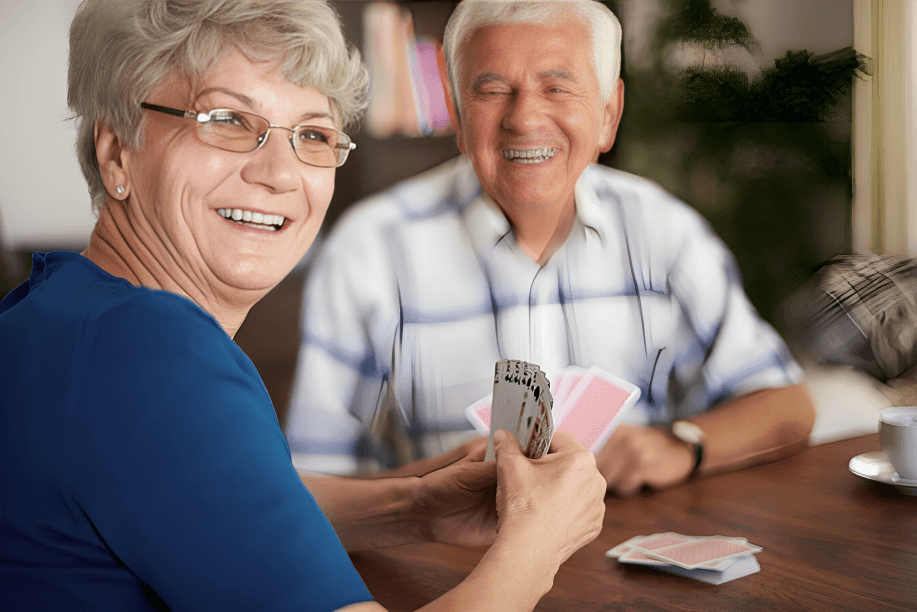 A happy senior couple playing cards together.