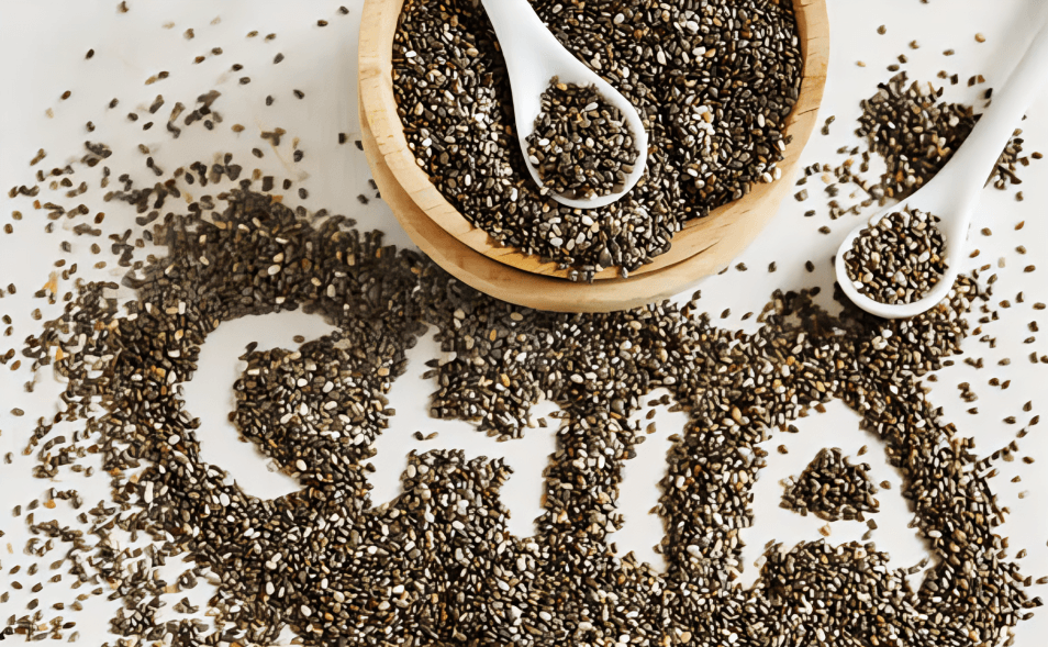 Chia seeds in a bowl and spoons on a white surface.