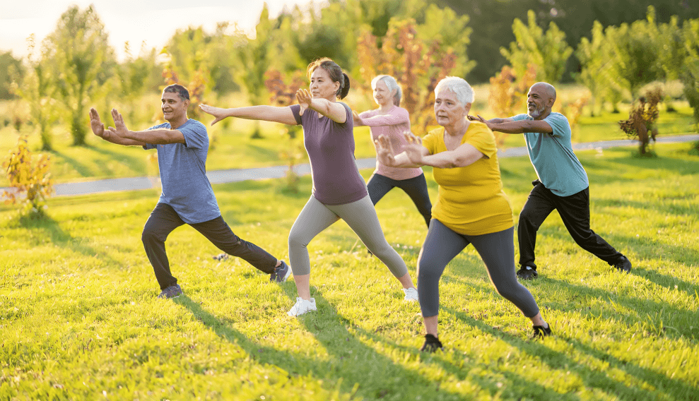 Group of diverse people practicing Tai Chi in nature.