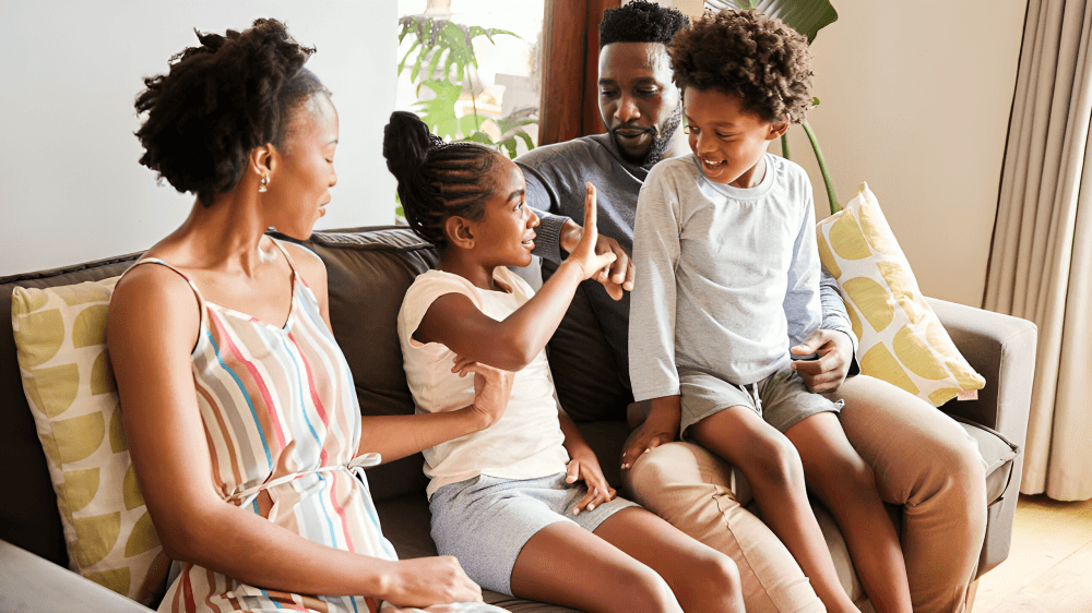 A family, sitting together on a couch.