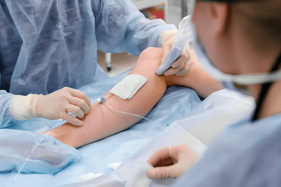 Medical professionals performing a procedure on a patient's leg.