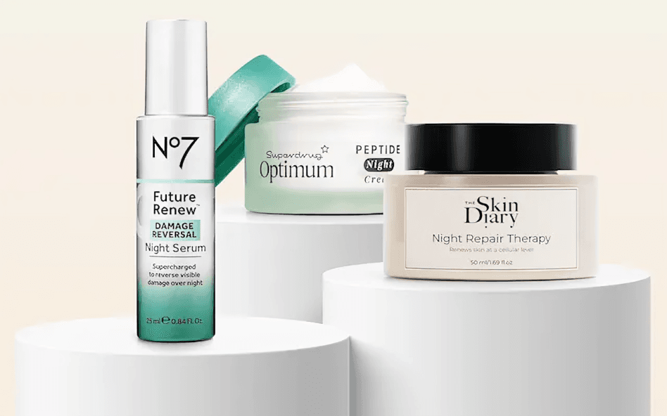 Various skincare products displayed on white pedestals.