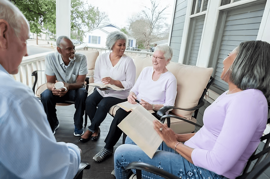 A group of diverse seniors chatting on a porch.
