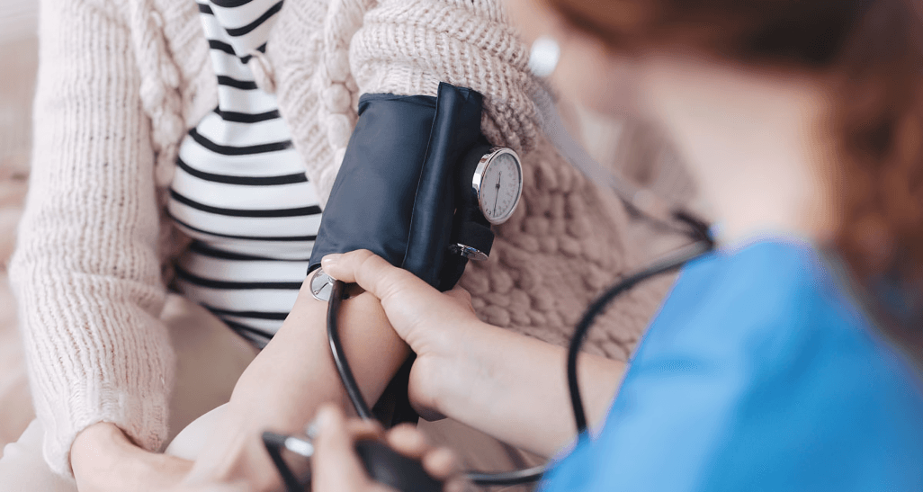 A nurse takes a patient's blood pressure.
