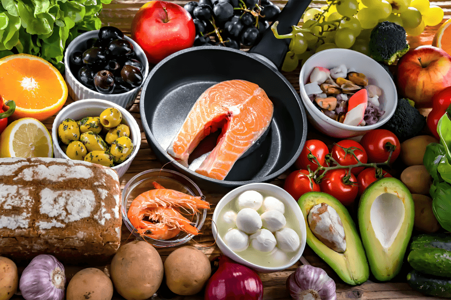 A variety of fresh, colorful foods arranged on a wooden surface.