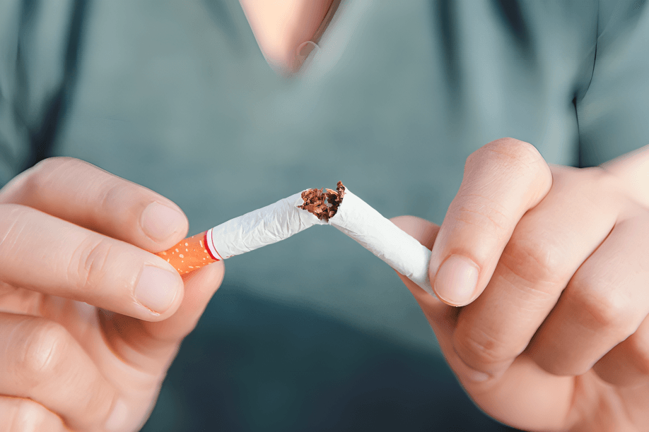 Hands breaking a cigarette in half.