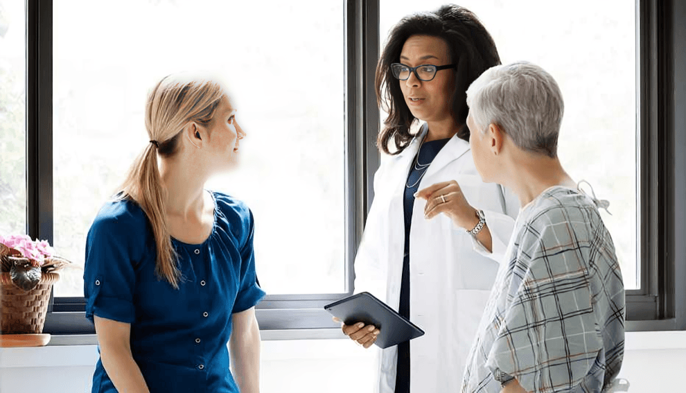 A doctor speaks to two women, one a patient.