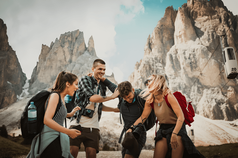 A group of friends laughing and hiking in the mountains.
