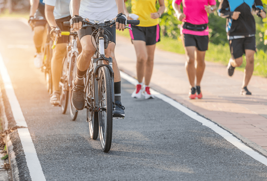 A group of people cycling and jogging outdoors.